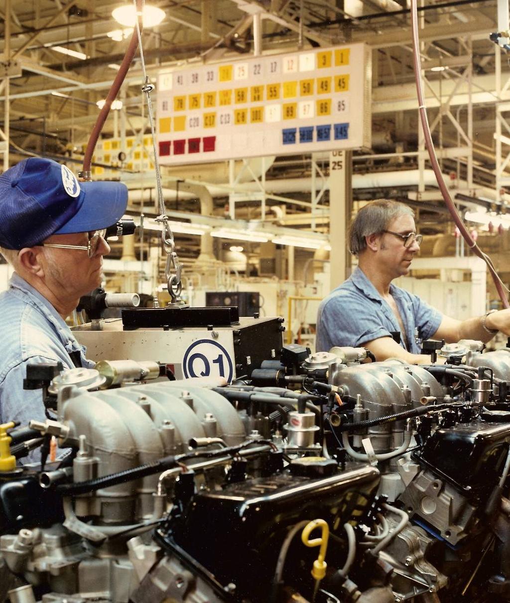 Assembly workers on an engine assembly line (photo