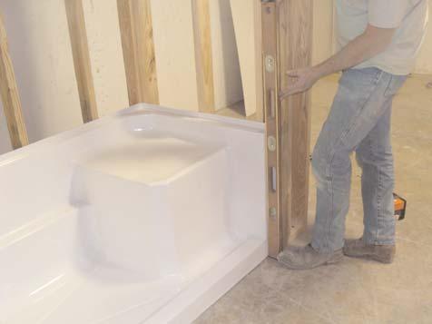 Carefully place the shower base into the framed pocket. Do not slide shower base on drain fitting. Use care not to knock the wood shims loose when moving the shower base into the installed position.