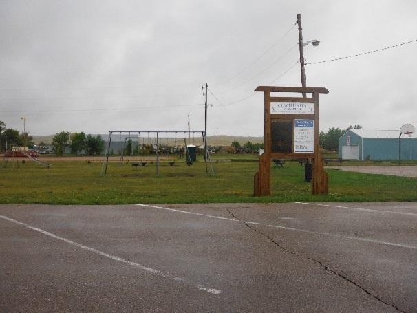 The park includes green space, basketball courts, picnic shelter, and a playground.