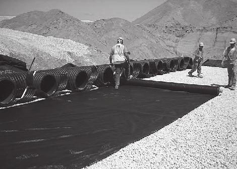 Place non-woven geotextile over prepared soils and up excavation walls. Install underdrains if required.
