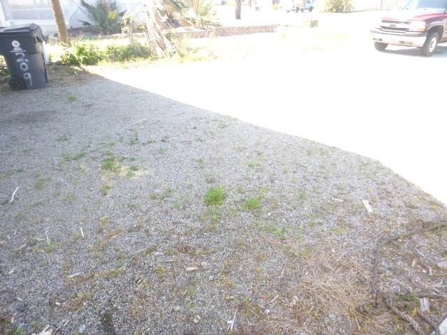 Driveway: Overall view of gravel driveway Driveway: View of negative slope in gravel driveway near roll up door WALKS / STEPS Wood Recommend Repairs General