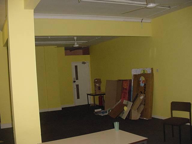 Walls: Painted yellow with three yellow painted columns on the right hand side Floors: Carpet tiles Fluorescent tubes which have