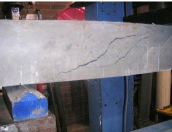 vertically. This crack caused the composite material to separate and debond from the concrete surface under the loading as seen in Figure 5(b).