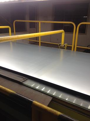 A line trial at Panzhihua Iron and Steel Company; (a) MPT rolling-applied onto a moving galvanized steel sheet, (b) MPT-treated GI sheet