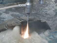The abrasive water jet cuts by directing a stream of water carrying a Garnet abrasive through a diamond, sapphire or ruby nozzle orifice at 55,000 psi pressure.