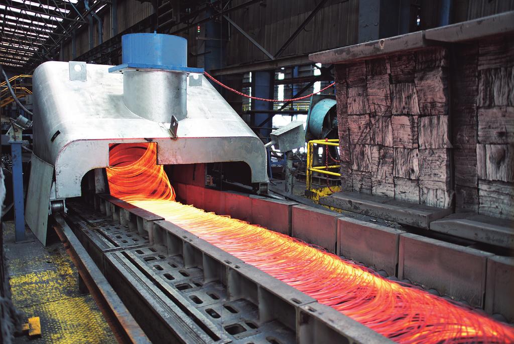 At the end of the roller conveyor the 2.5 t coils are regularly formed and vertically conveyed in their as-formed condition to the coil compacting and tying station by a vertical trestle line.