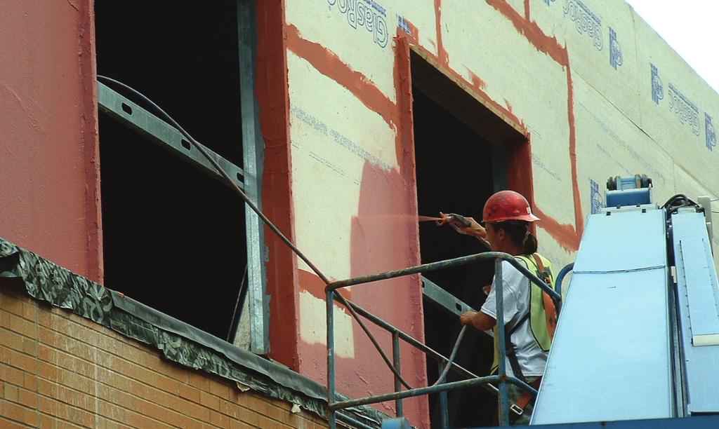 Application of a spray-applied liquid air barrier over a gypsum-based sheathing, note the use of self-adhering sheet membranes used as flashings at the shelf angle.