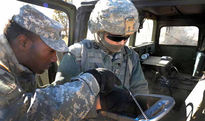 A 3rd Cavalry Regiment motor transport operator configures the route for an autonomous convoy using a ruggedized tablet while a Combined Arms Support Command officer reviews the plan.