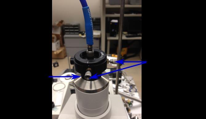Figure B.2. Photograph of the blue optical cable connected to the top port of the microscope. Adjustment screws are used to set the x and y alignment. Spacers are used to set the z alignment.