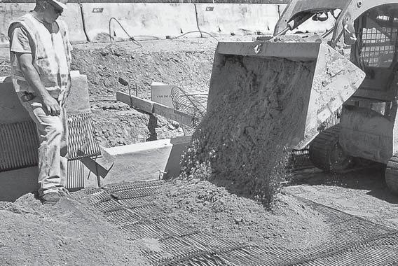 Select fill is placed on the geogrid between the back of the panel and the tensioning rake.
