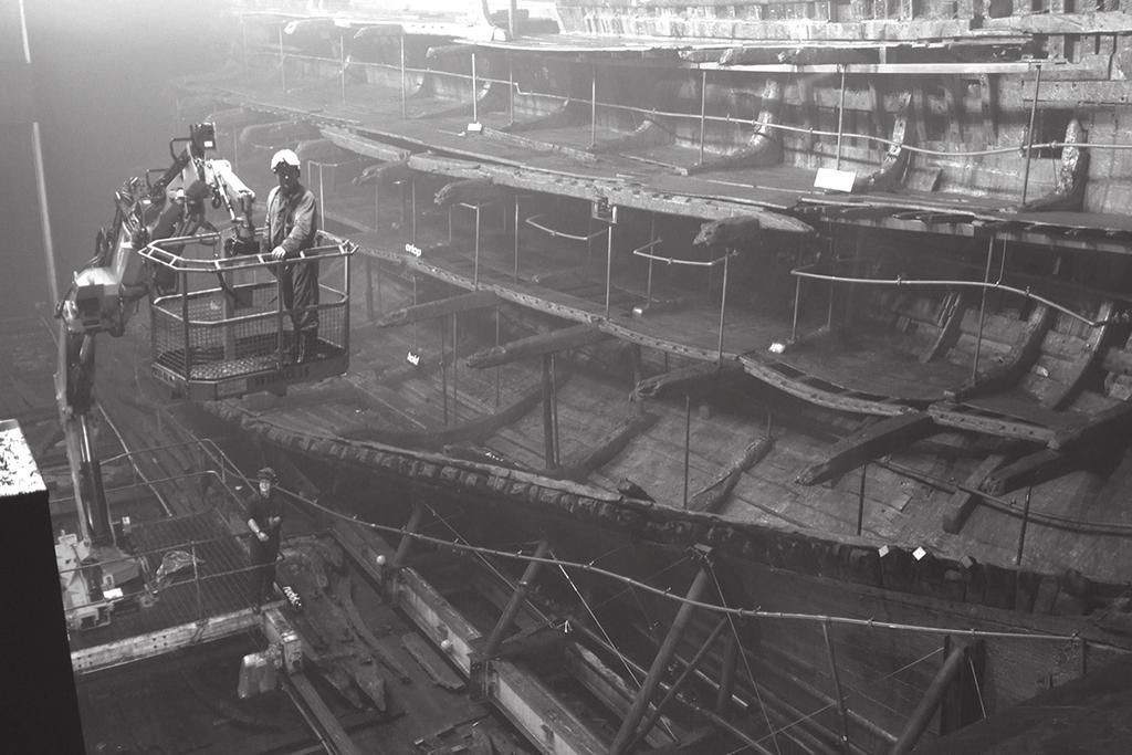 27 13 (b) Figure 12 shows the Mary Rose being supported on poles as it is preserved. As part of the preservation process the ship was sprayed with water for 12 years.