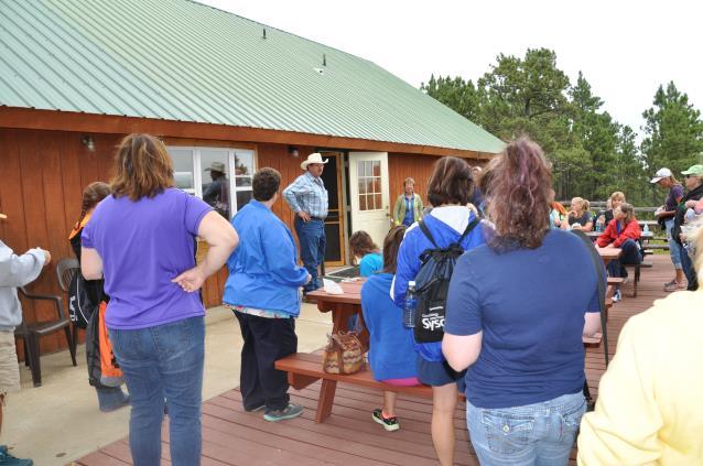 John Hanson welcomes the teachers to the Logging Camp Ranch near the edge of the ponderosa pine forest.