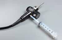 Remove the 60 cc syringe from the connector and draw up 40 cc of sterile water from the water container. 4. Attach the syringe to the suction/biopsy connector on the light guide end on the universal cord.