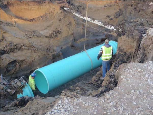 LOWERING PIPE INTO THE TRENCH: Place the pipe and fittings into the trench using ropes and skids, slings on the backhoe bucket, or by hand.