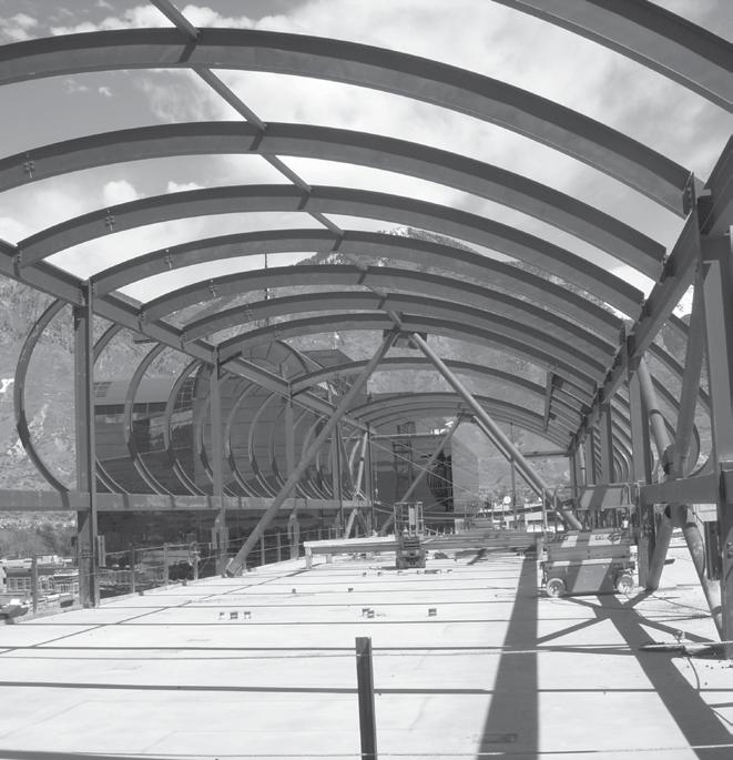 The glass roof is supported by steel girders that span between the north and south buildings, along with intermediate steel beams and tension bracing, and the translucent glass ceiling is hung from