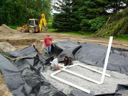 The filter is comprised from top to bottom of: a 0.2 m layer of Sphagnum peat moss, a 0.4 m layer of 1-5 mm washed sand, a 0.2 m drainage layer of 13-20 mm washed gravel and a 30 mil PVC liner.
