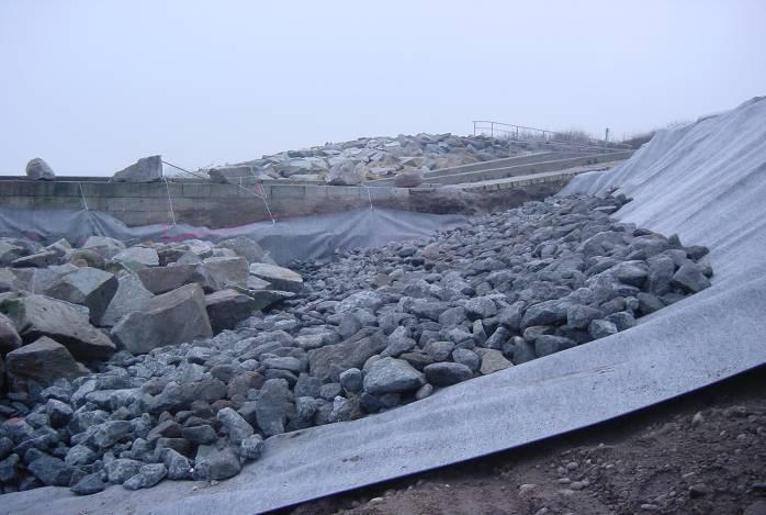 Behind the skid foot model the revetment is constructed with geotextile, filter layer and cover layer from the existing water building blocks or water building blocks which are to be newly delivered