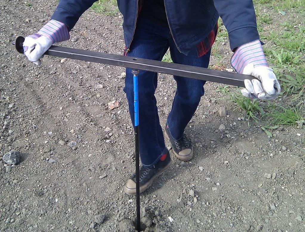 First, ground anchors are driven into the ground at predetermined locations. The tripod frame is then set over it.