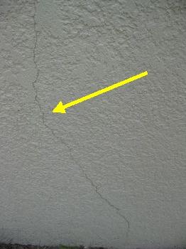 The exterior stucco has several small cracks on the surface.