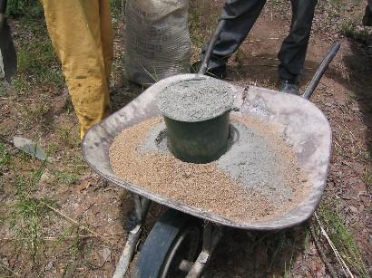 This is mixed thoroughly in a wheel barrow before adding water. The sand and cement must be very well mixed.