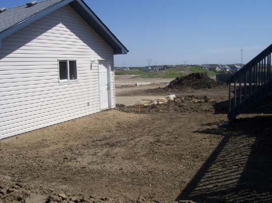 Surface drainage is directed towards the internal swale between the house and the detached garage, the side-lot swales and towards a City right-of-way.