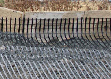 Once compacted and ~leveled place geogrids with grid directional strength, perpendicular to the wall face.