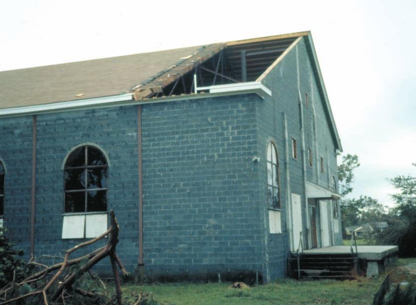 Photo 2: Because of inadequate joist attachment, the entire roof assembly (i.e., joists, plywood decking, and asphalt shingles) blew off as a single unit and landed about 135 m (450') from the building.