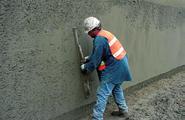 Nails are drilled at each lift, with steel bars grouted into 4 to 6 inch diameter holes. The wall facing is constructed by embedding steel nail head plates into lightly reinforced shotcrete.