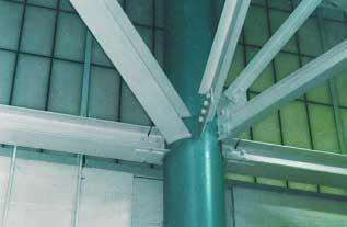 A plate welded to the top flange of truss T1 upper chord is detailed to accommodate the intersecting slopes in two directions and to allow the temporary placement of the different trusses until