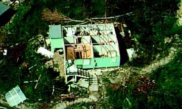 FIGURE 3-20 Aerial view of a residential concrete/masonry structure with a wood-frame roof structure; only the roof rafters remain. The wood nailers and metal panels were blown off. 3.4.