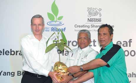 to a charity home representative. More than 100,000 trees were planted along the lower Kinabatangan River in Sabah [From left to right] Mr.