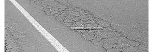 Pavement surface with overlay fabric Typical alligator cracks on the pavement surface Pavement surface without