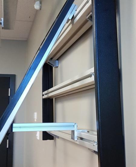 b) Once the Monitor Security Lock has been positioned directly on top of panel clamp, secure the lock by tightening the