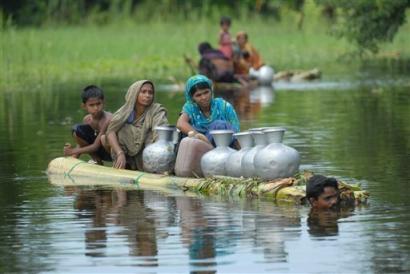 A flood affected family leaves their home for a relief center on a makeshift tube raft at Balrampur village, in Gorakpur district, in the