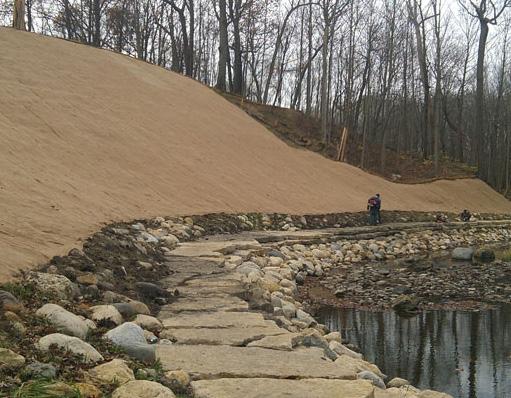 The bluff slope was re-graded behind the stone toe and stabilized with coir roll and erosion control blanket.