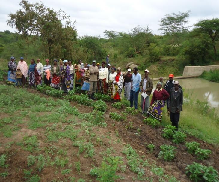 Photo; community members beside their sand dams which are holding large volumes of water 2.