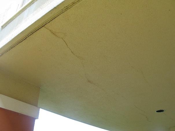 Figure 9: Fractured stucco at a column pedestal Figure 10: Fractured stucco at a balcony soffit Initial finish removal exposed a deteriorated wood beam at the balcony fascia and adjacent to the