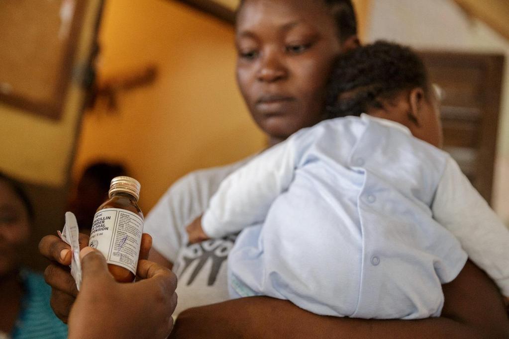 Liliane Kandeh and her son picking up their malaria drugs, Freetown, Sierra Leone. UNICEF/Asselin.