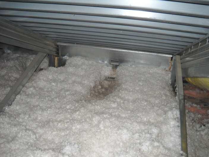 One exception to the previously described attic insulation condition was observed in the area directly above room E211.