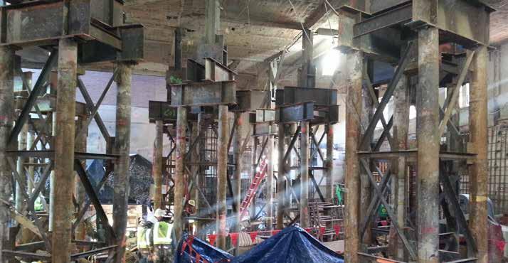 Interior columns were re-supported on new steel micro-pile groups (four per column) drilled through existing foundations prior to excavation, with wide-flange steel grillage spanning from micro-pile